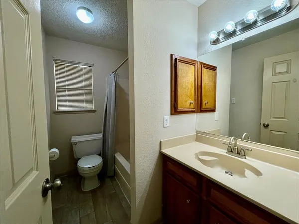 a bathroom with a sink vanity granite and toilet