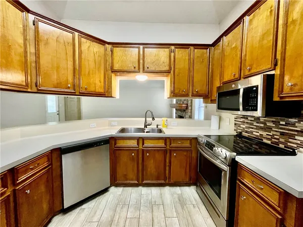 a kitchen with stainless steel appliances a sink stove and cabinets