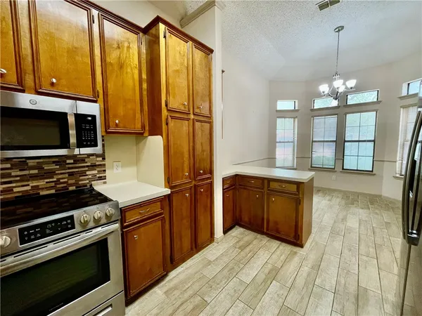 a kitchen with stainless steel appliances a stove sink and microwave