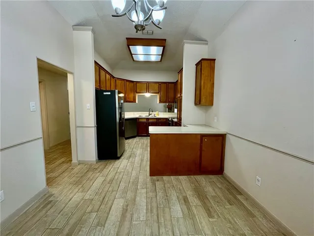 a view of a kitchen with a refrigerator and a microwave