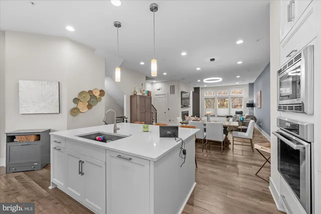 a kitchen with stainless steel appliances kitchen island granite countertop a table chairs and a refrigerator