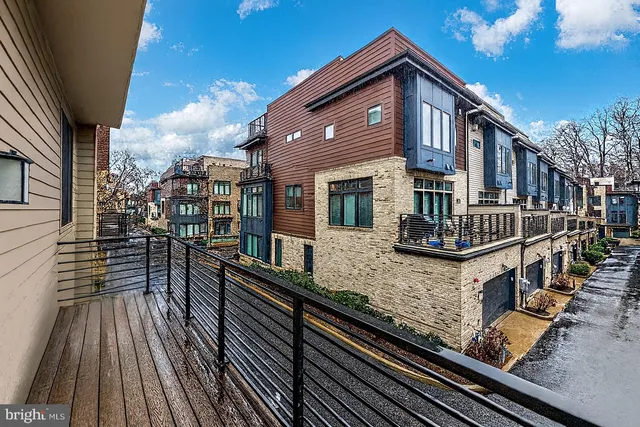 a kitchen that has a lot of cabinets a sink a stove and chairs in it