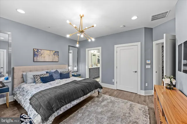 a bedroom with a large bed and a chandelier