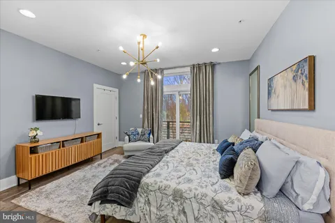 a spacious bedroom with a large bed and a chandelier