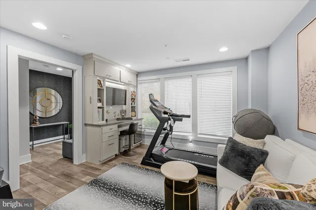 a living room with furniture a flat screen tv and a refrigerator