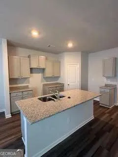a kitchen with granite countertop a sink a stove and cabinets