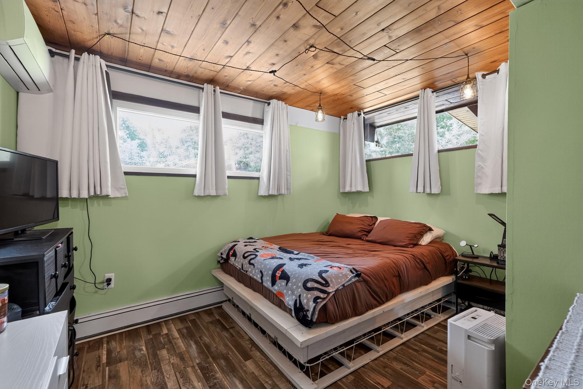 424 Laroe Road Chester, NY 10918 - Photo 13 of 43 Wood-finish flooring and a wood plank ceiling define this room, featuring light green walls and multiple windows
