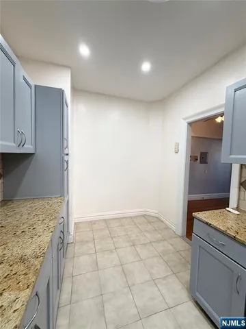 a kitchen with granite countertop a sink and cabinets