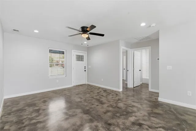 a view of room with a ceiling fan and entryway
