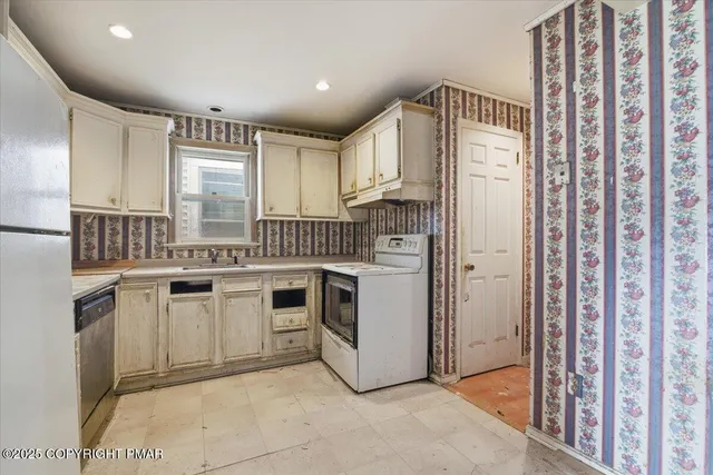 a kitchen with white cabinets and white appliances