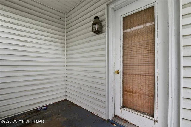 a white house that has a small yard and large trees