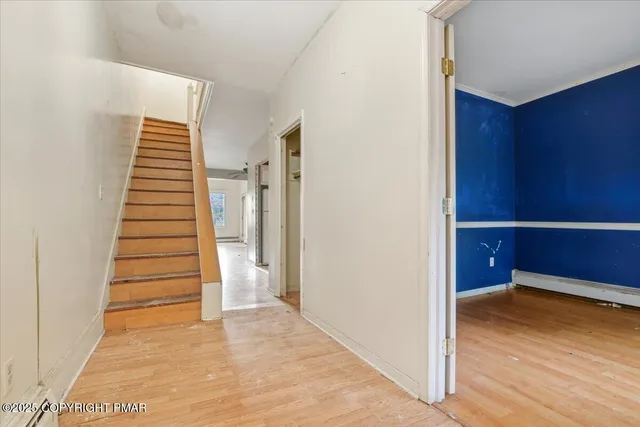 a view of a hallway with wooden floor and entryway