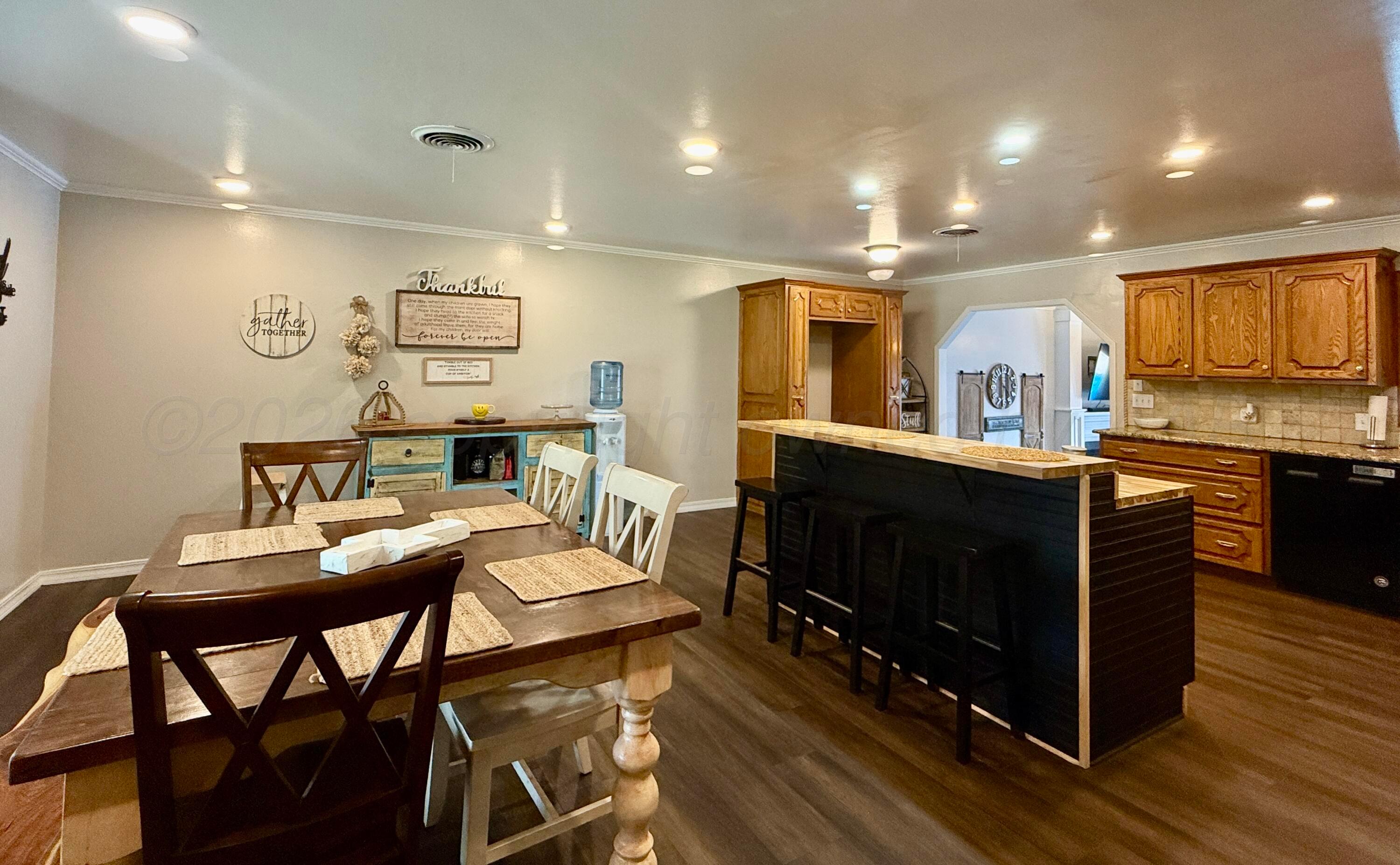 219 Inverness Street Borger, TX 79007 - Photo 11 of 35 a kitchen with a table chairs refrigerator and microwave