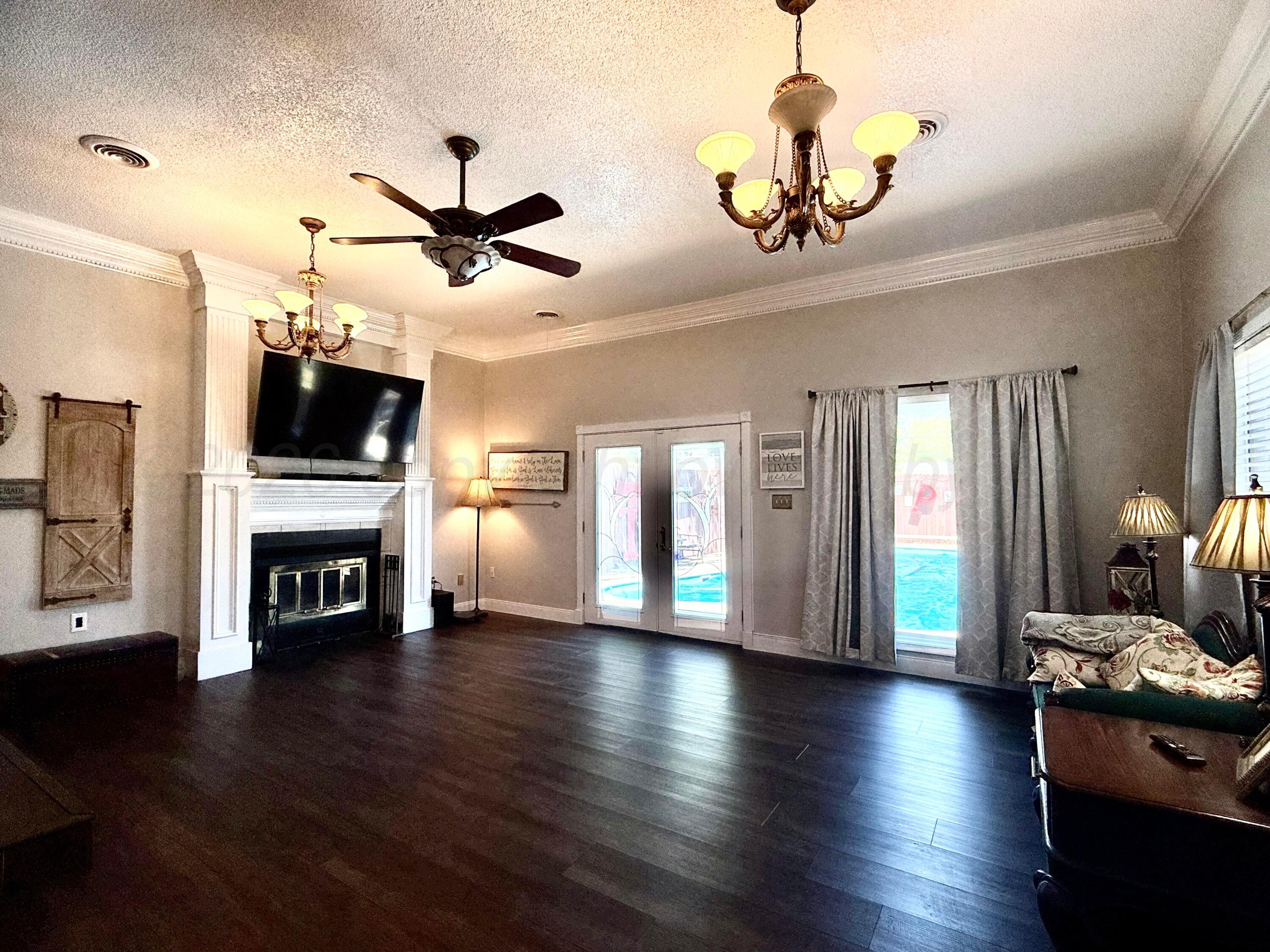 219 Inverness Street Borger, TX 79007 - Photo 14 of 35 a view of a livingroom with fireplace wooden floor and a ceiling fan