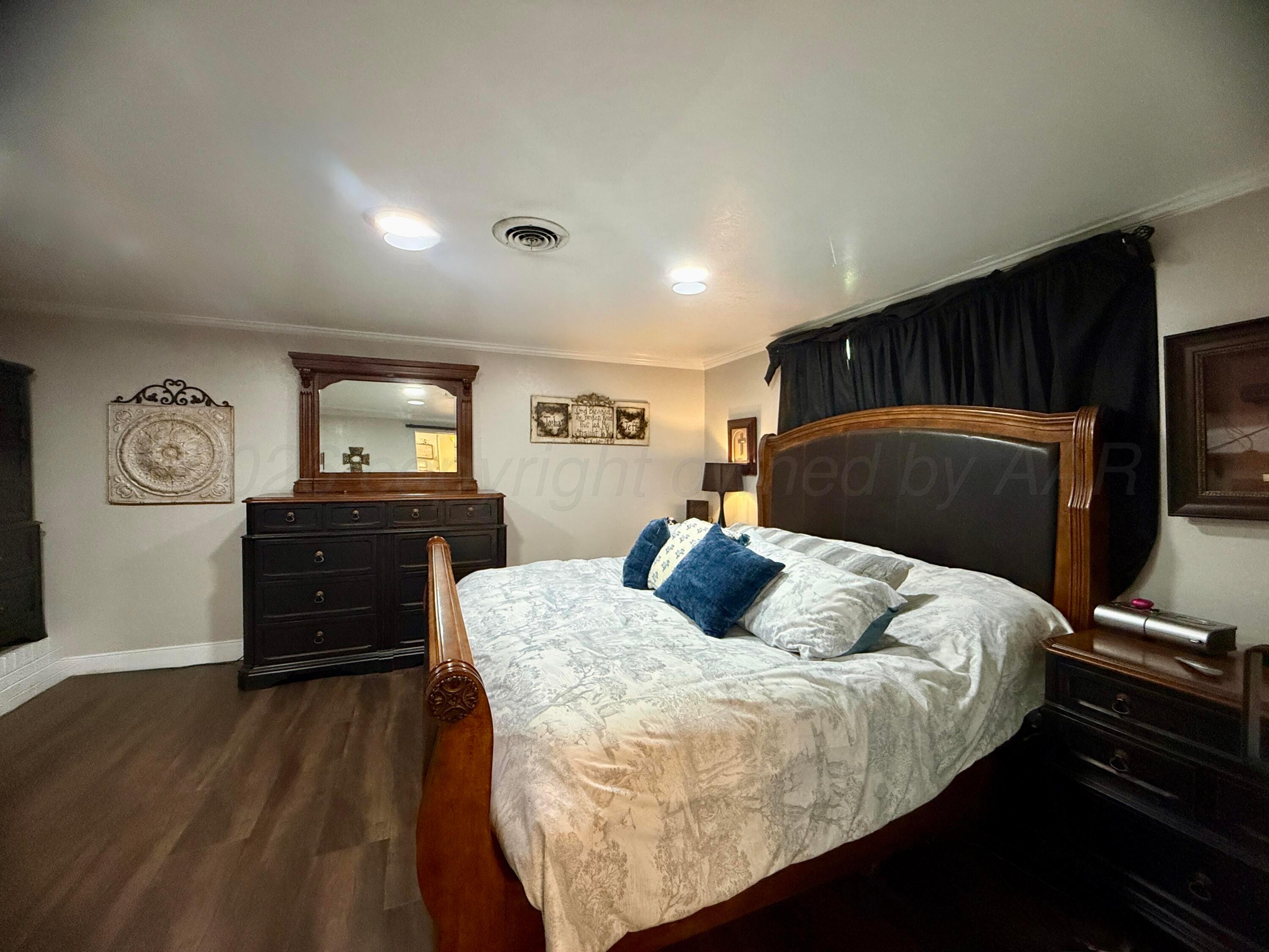 219 Inverness Street Borger, TX 79007 - Photo 17 of 35 a bedroom with a bed and a dresser
