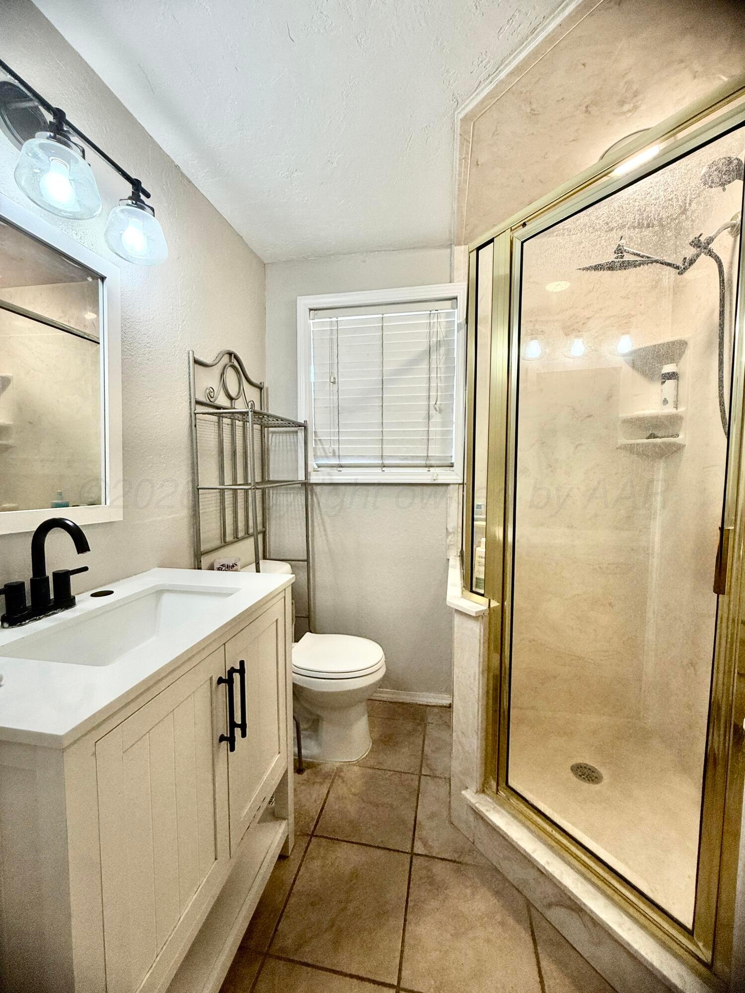 219 Inverness Street Borger, TX 79007 - Photo 19 of 35 a bathroom with a sink mirror toilet and shower