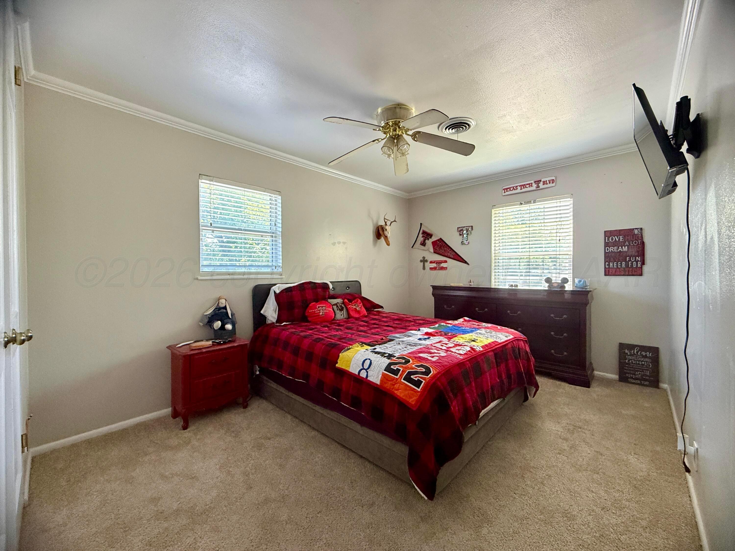 219 Inverness Street Borger, TX 79007 - Photo 22 of 35 a bedroom with a bed and a chandelier