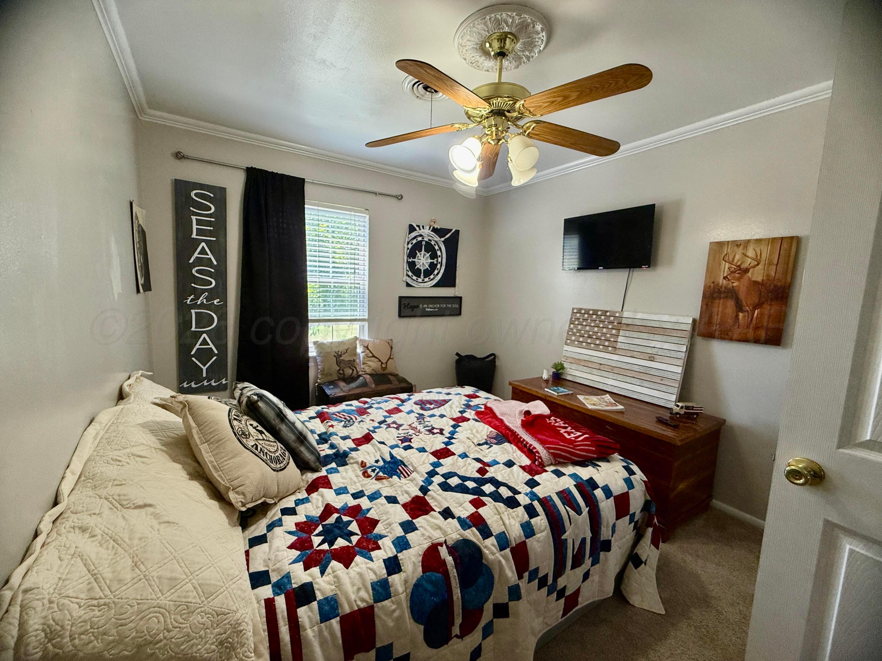 219 Inverness Street Borger, TX 79007 - Photo 23 of 35 a bedroom with a bed and a chandelier