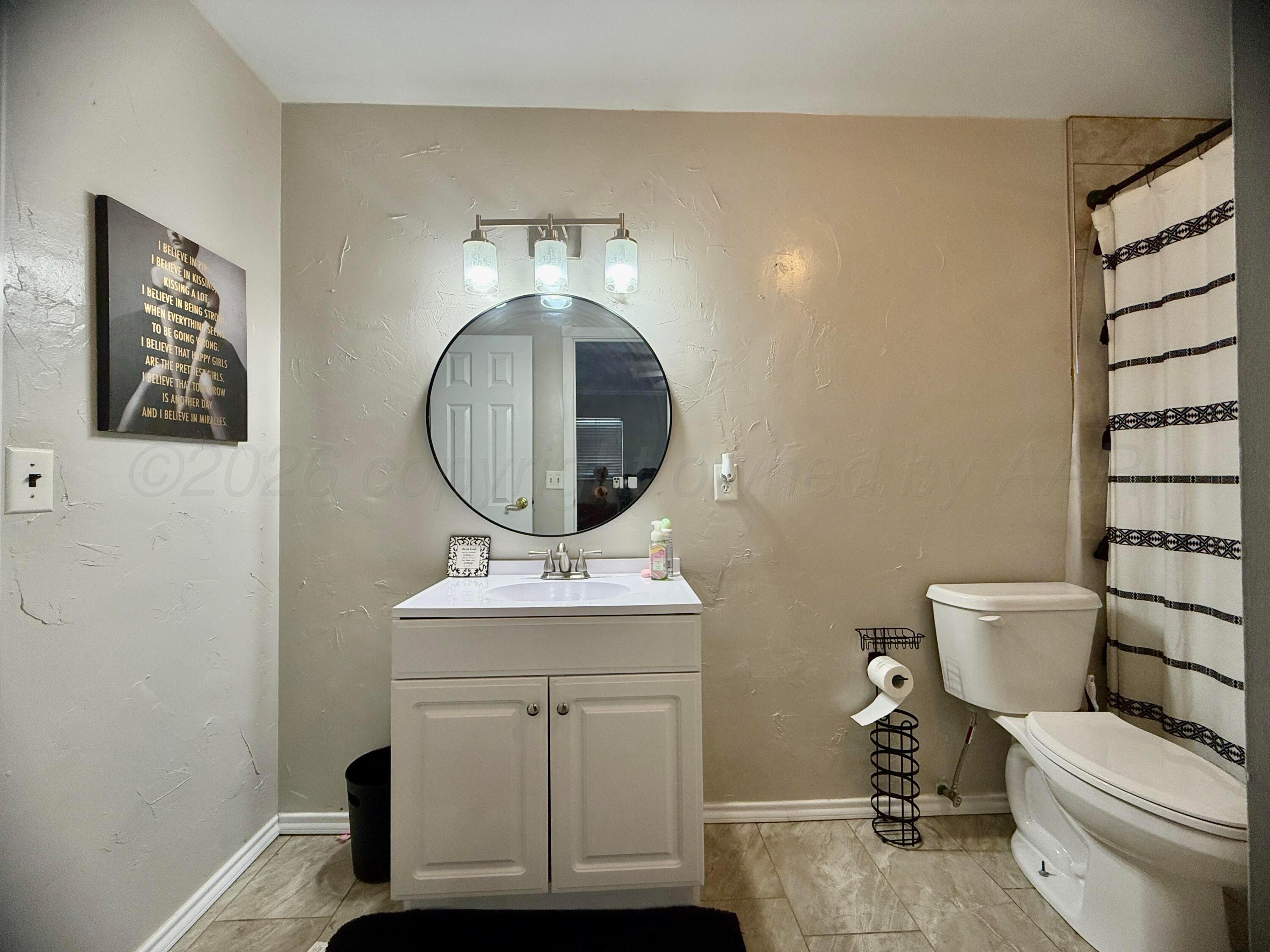 219 Inverness Street Borger, TX 79007 - Photo 25 of 35 a bathroom with a toilet a sink and mirror