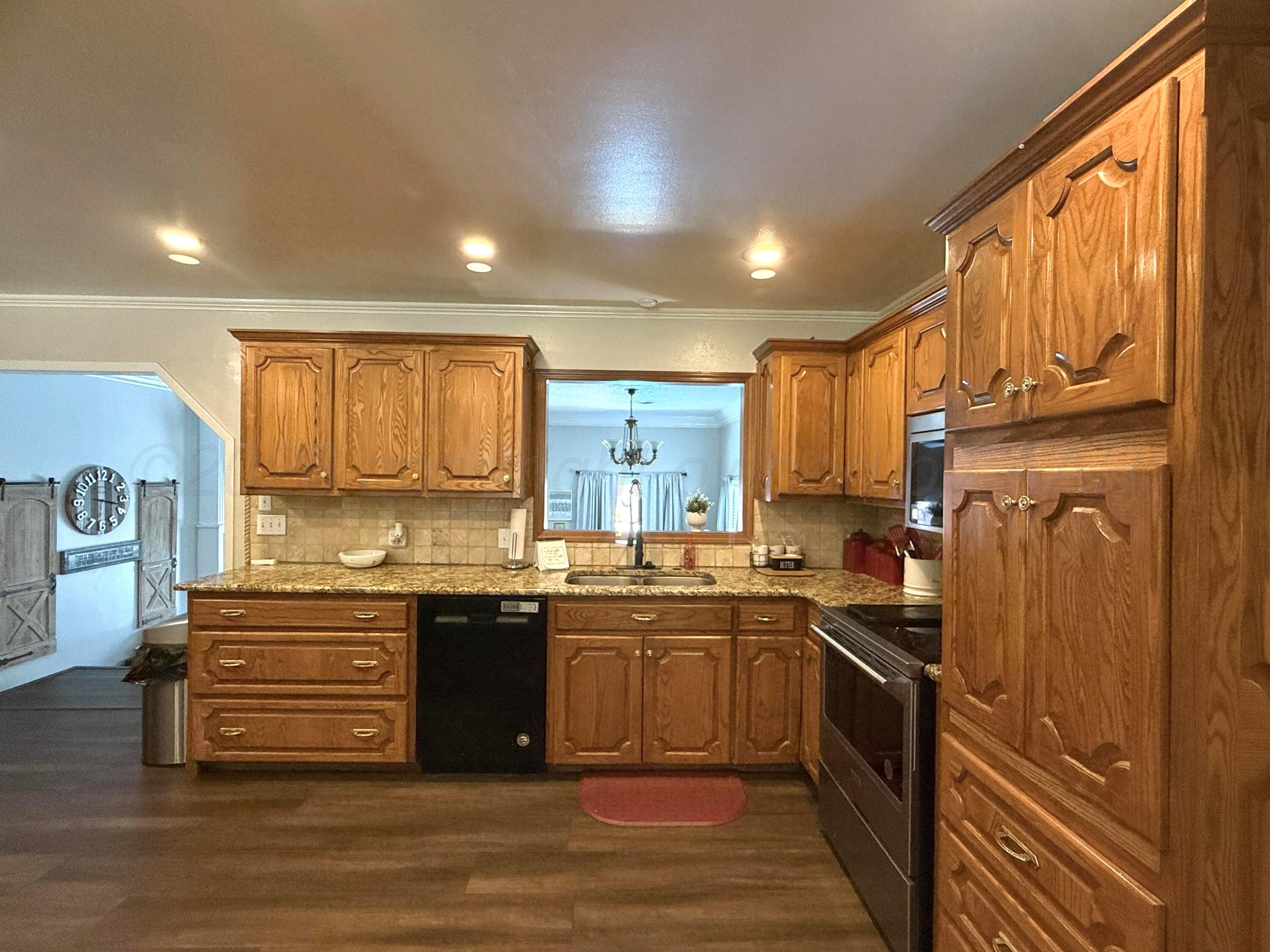 219 Inverness Street Borger, TX 79007 - Photo 6 of 35 a kitchen with stainless steel appliances granite countertop a sink stove and refrigerator
