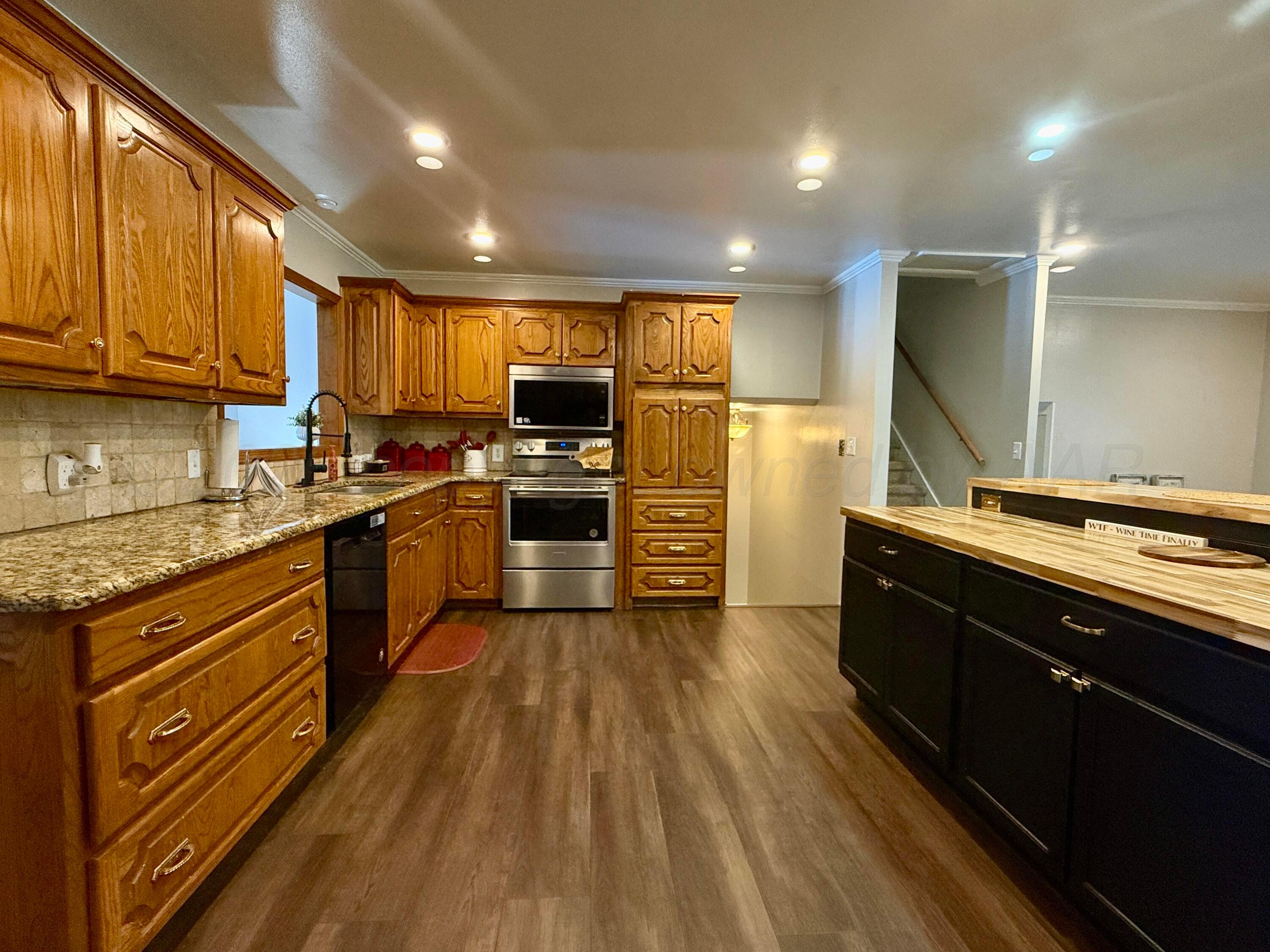 219 Inverness Street Borger, TX 79007 - Photo 7 of 35 a kitchen with wooden floors appliances and cabinets