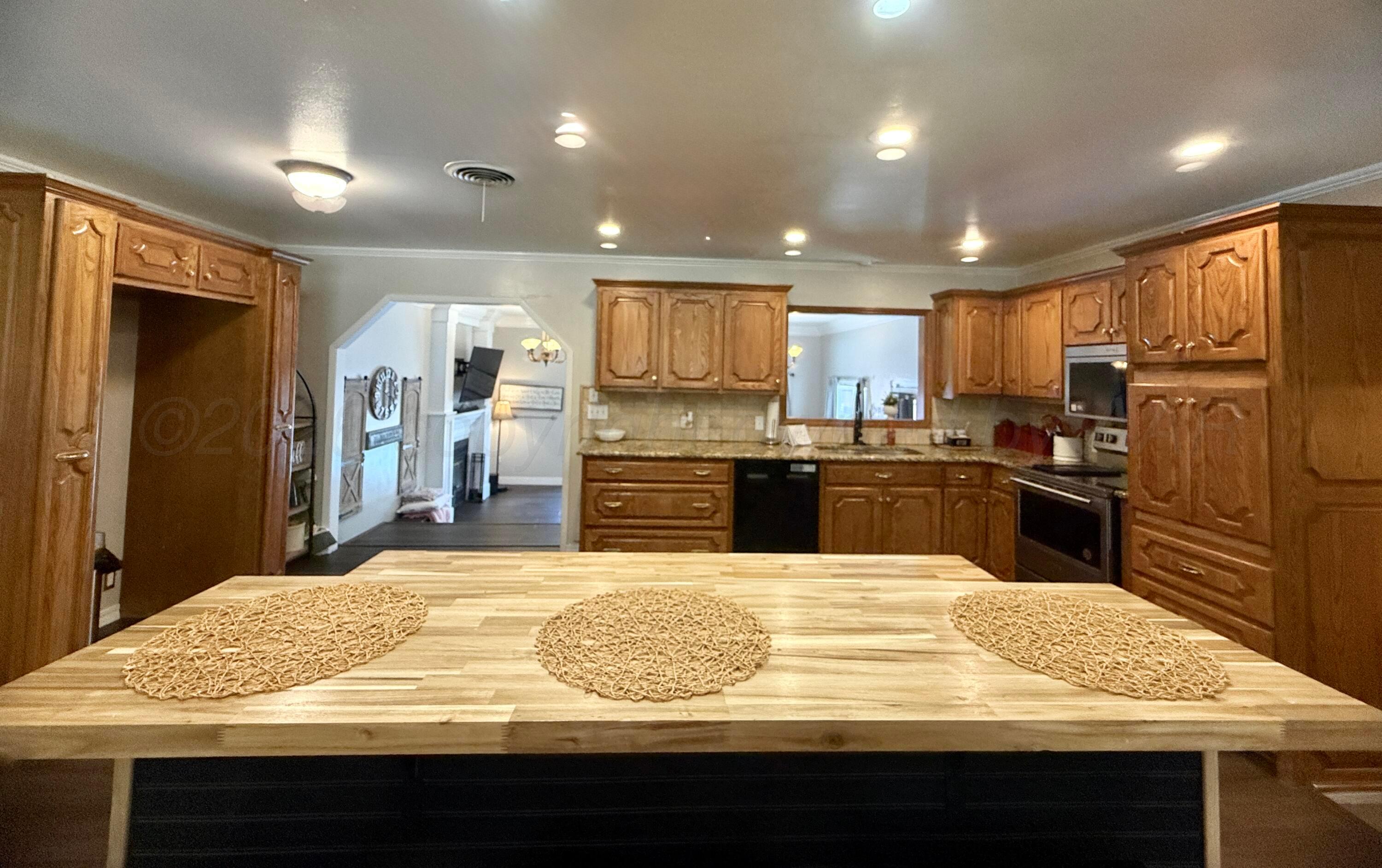 219 Inverness Street Borger, TX 79007 - Photo 8 of 35 a kitchen with kitchen island sink refrigerator and cabinets