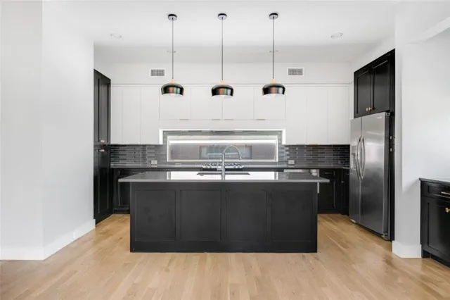 a kitchen with kitchen island stainless steel appliances a stove a sink and a refrigerator