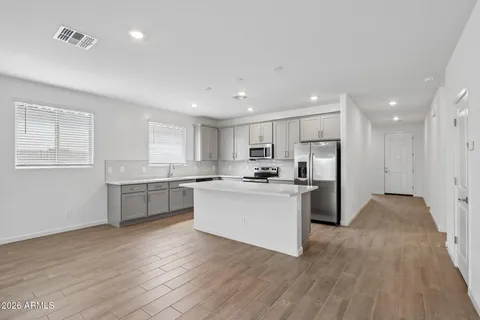 a kitchen with a refrigerator and white cabinets