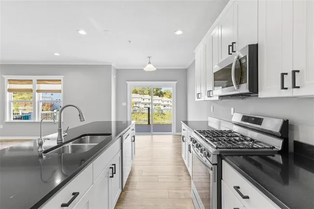 a kitchen with stainless steel appliances a sink stove and cabinets