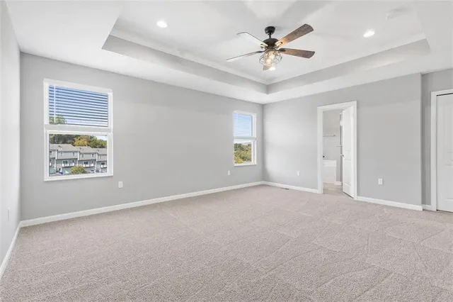an empty room with ceiling fan and window