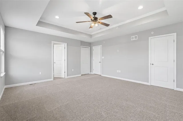 an empty room with closet and ceiling fan