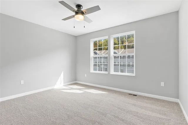 an empty room with a window and a fan