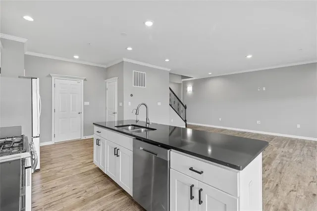 a large kitchen with stainless steel appliances granite countertop a sink and a refrigerator