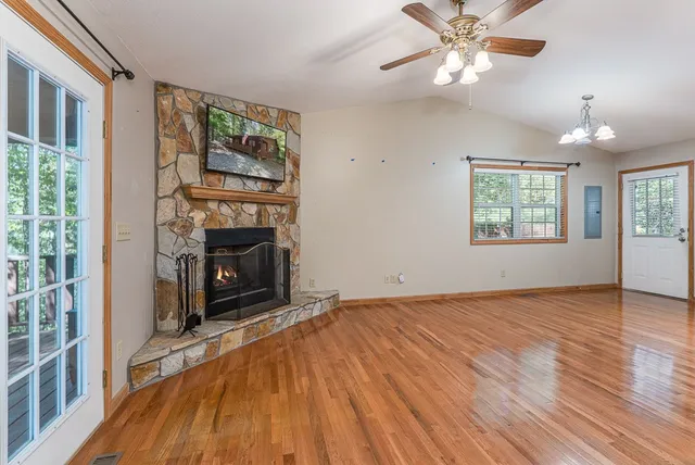 wooden floor fireplace and windows in an empty room