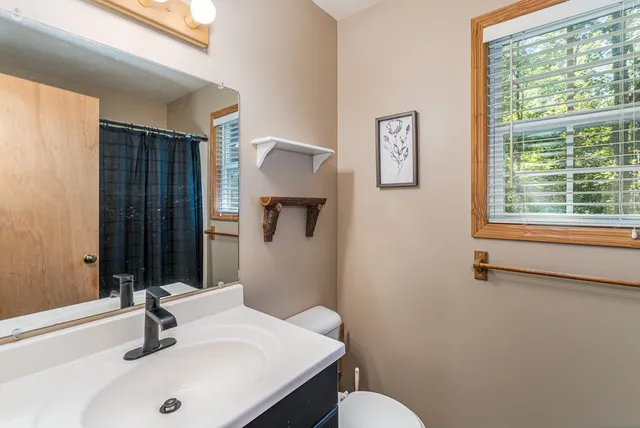 a bathroom with a sink toilet and a mirror