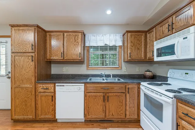 a kitchen with stainless steel appliances granite countertop a stove a sink and a microwave
