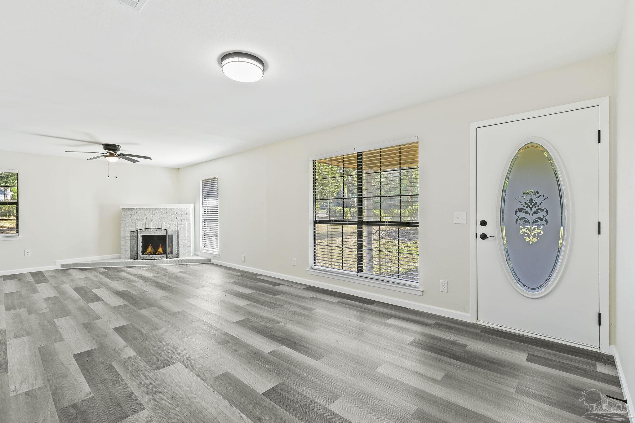 4200 Rigby Road Century, FL 32535 - Photo 12 of 71 a view of an empty room with a fireplace and a window