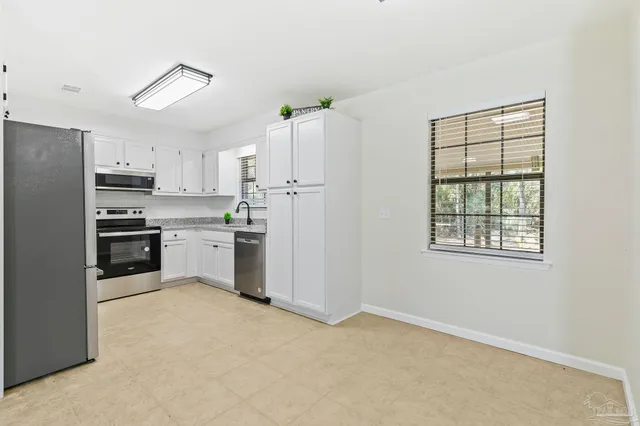 a kitchen with granite countertop white cabinets and appliances