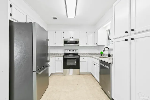 a kitchen with stainless steel appliances a refrigerator sink and stove