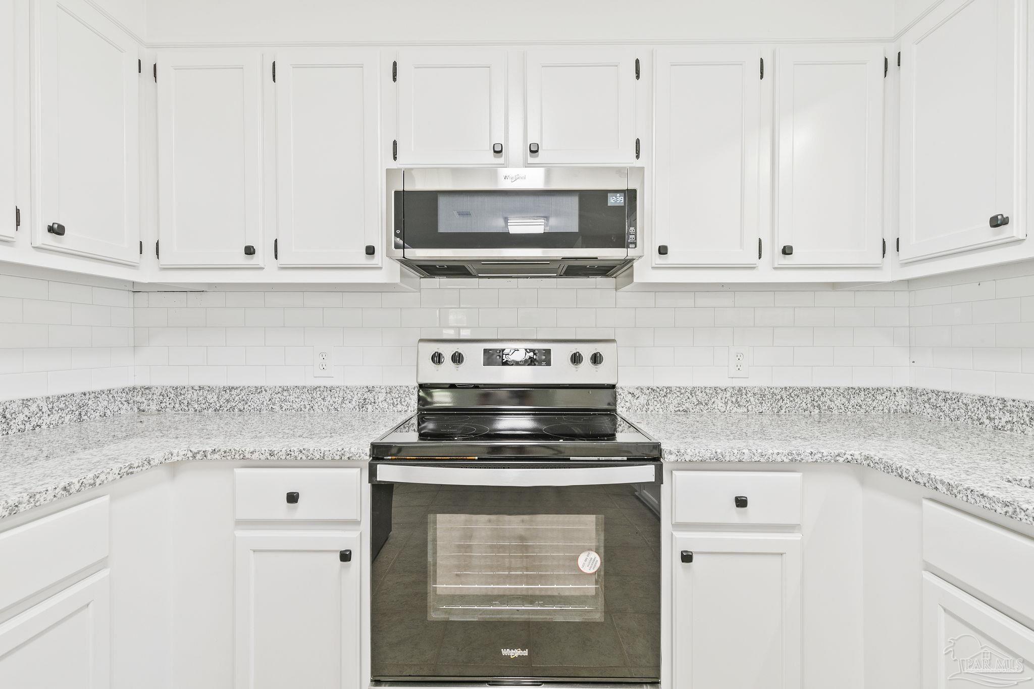 4200 Rigby Road Century, FL 32535 - Photo 19 of 71 a kitchen with granite countertop white cabinets and appliances