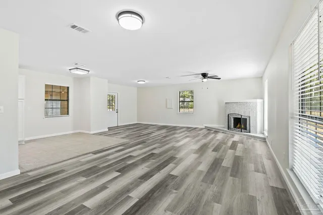 a view of empty room with windows and fireplace