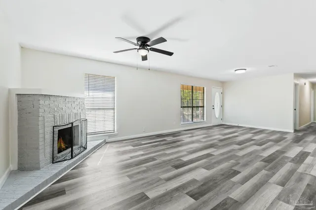 a view of empty room with fireplace and wooden floor