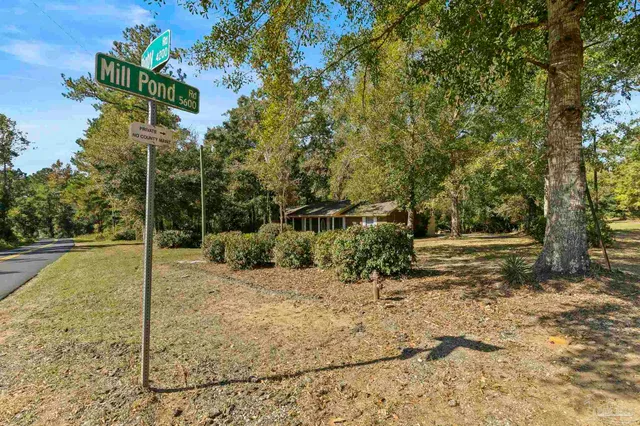 a backyard of a house with barbeque oven and wooden fence