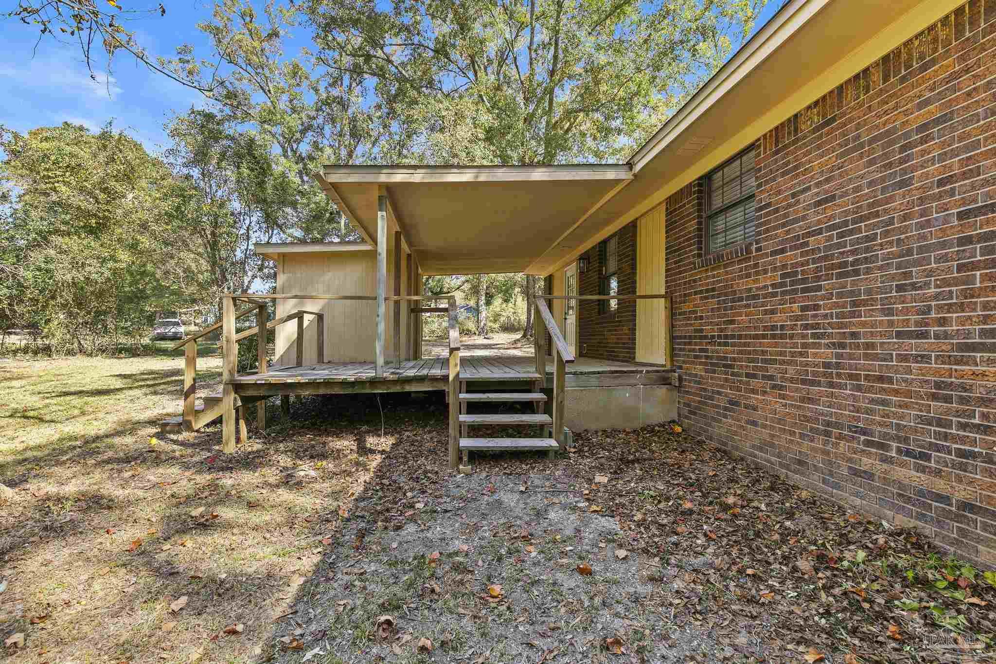 4200 Rigby Road Century, FL 32535 - Photo 56 of 71 a backyard of a house with barbeque oven and wooden fence