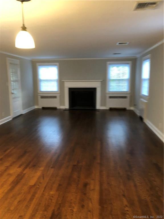 66 Hillandale Road, Unit 2 Fairfield, CT 06825 - Photo 20 of 33 an empty room with wooden floor fireplace and windows