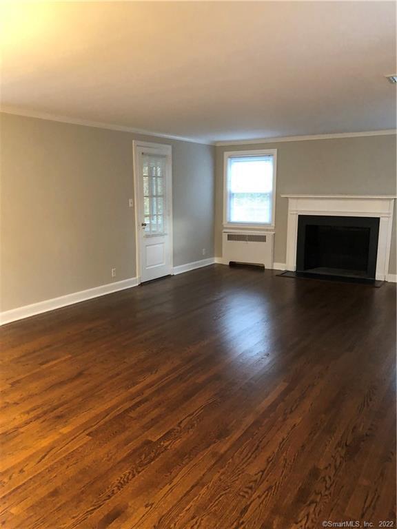 66 Hillandale Road, Unit 2 Fairfield, CT 06825 - Photo 22 of 33 an empty room with wooden floor fireplace and windows