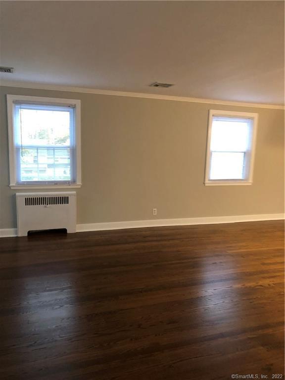 66 Hillandale Road, Unit 2 Fairfield, CT 06825 - Photo 26 of 33 an empty room with wooden floor and windows