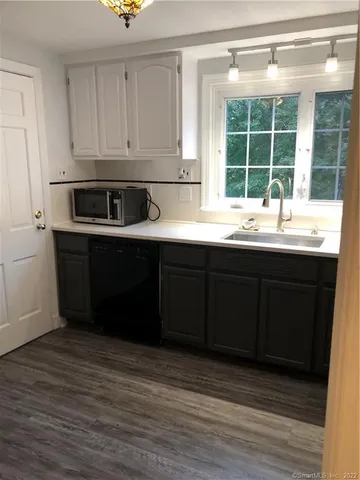a kitchen with stainless steel appliances granite countertop a sink and cabinets with wooden floor