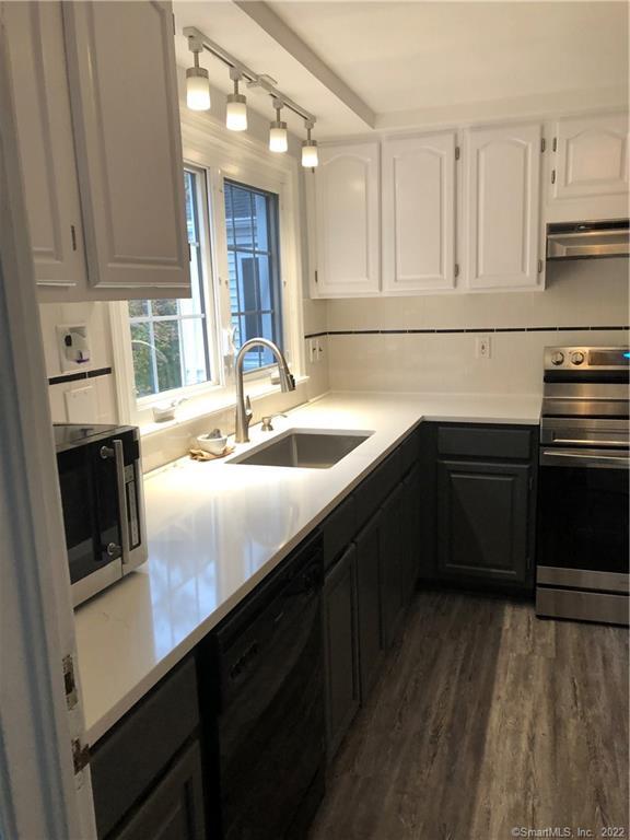 66 Hillandale Road, Unit 2 Fairfield, CT 06825 - Photo 9 of 33 a kitchen with a sink stove and cabinets