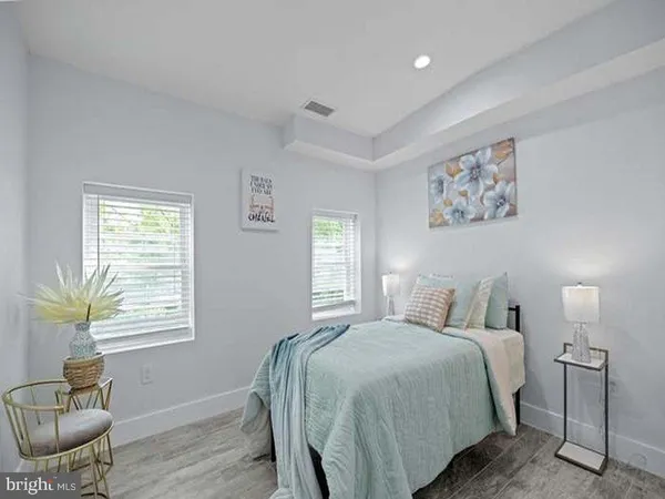 a bedroom with a bed and wooden floor